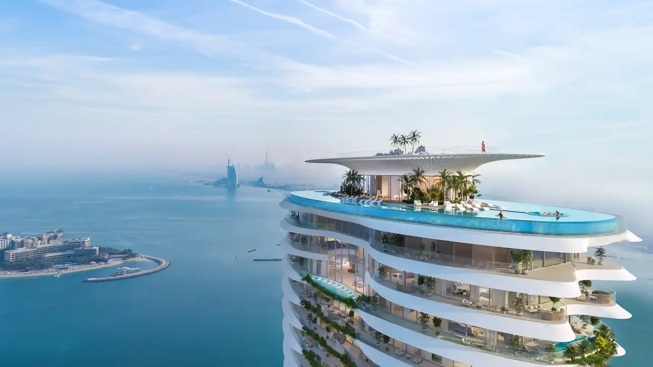 Sky-level infinity pool at COMO Residences featuring a floating rooftop deck, sculpted white architecture, panoramic Gulf views, Palm Jumeirah coastline, and the Dubai skyline in the distance. Presented by Tohid Fetrat.