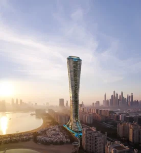 Aerial sunset view of COMO Residences tower highlighting its slender sculpted form, elevated pool terraces, beachfront base, and expansive Gulf and Dubai skyline surroundings on Palm Jumeirah. Presented by Tohid Fetrat.
