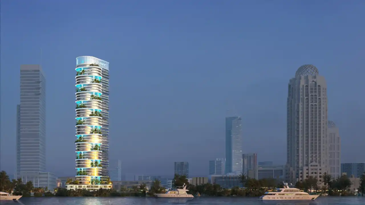 Night waterfront view of the DAMAC Casa tower, highlighting its illuminated curved balconies, vertical greenery, and contemporary high-rise architecture along Dubai’s skyline. Presented by Tohid Fetrat.