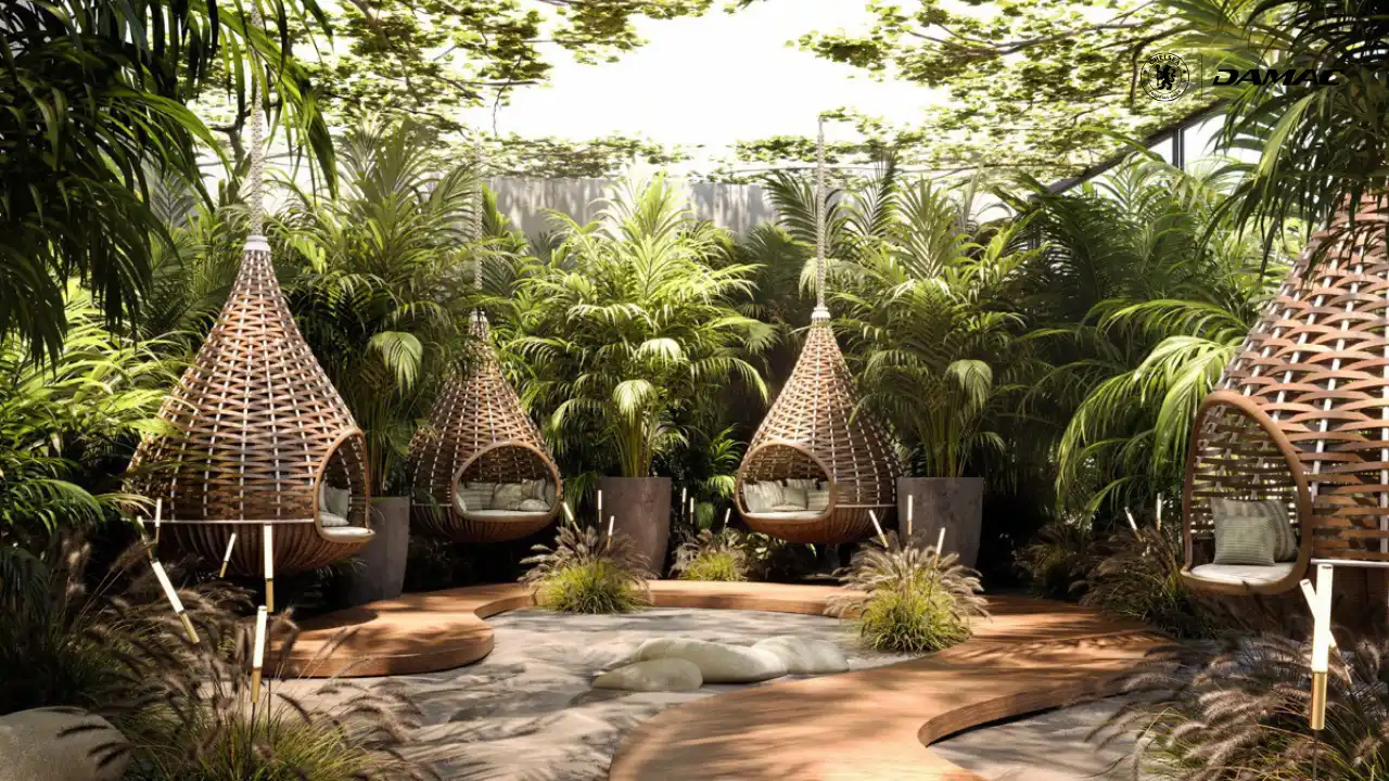 نمای باغ از پادهای ریلکسیشن جنگلی در داماک چلسی رزیدنسز با صندلی های آویز حصیری، پوشش گیاهی انبوه و فضای آرام سلامت در فضای باز دبی، ارائه شده توسط توحید فطرت