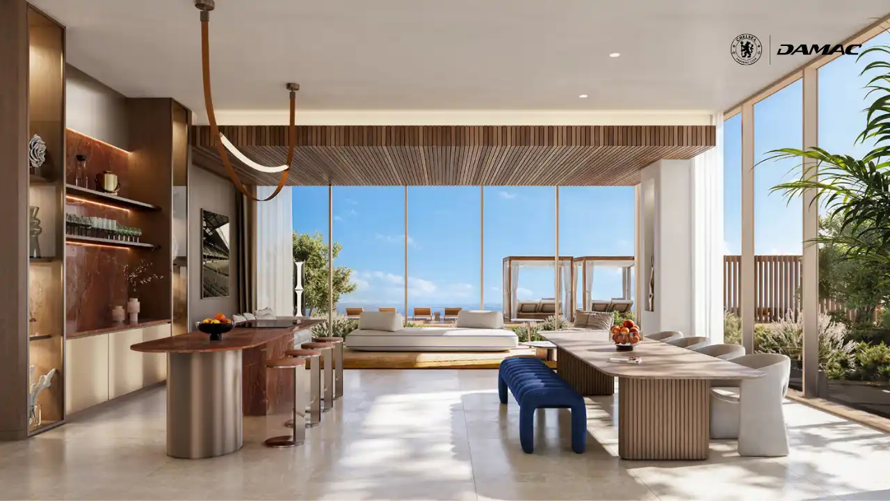 Interior view of the healthy fine dining restaurant at DAMAC Chelsea Residences featuring elegant dining tables, a refined bar area, natural materials, and floor to ceiling windows opening to landscaped outdoor seating in Dubai, Presented by Tohid Fetrat