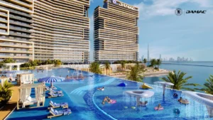 Family friendly kids pool at DAMAC Chelsea Residences featuring shallow play areas, water features, striped loungers, and palm lined decks with waterfront views in Dubai, Presented by Tohid Fetrat