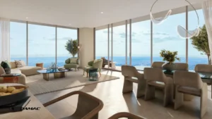 Interior view of the living and dining area at DAMAC Chelsea Residences featuring floor to ceiling windows, soft contemporary furnishings, sculptural lighting, and open sea views in Dubai, Presented by Tohid Fetrat