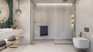 Interior view of the master bathroom at DAMAC Chelsea Residences featuring a spacious glass shower, refined stone surfaces, modern sanitary fittings, and soft ambient lighting in Dubai, Presented by Tohid Fetrat