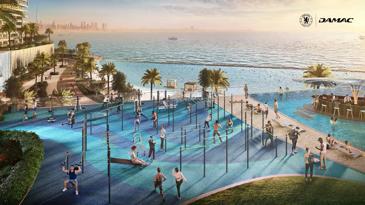 Outdoor gym at DAMAC Chelsea Residences featuring open air fitness equipment, rubberized workout surfaces, palm lined surroundings, and direct waterfront views across the Gulf in Dubai, Presented by Tohid Fetrat