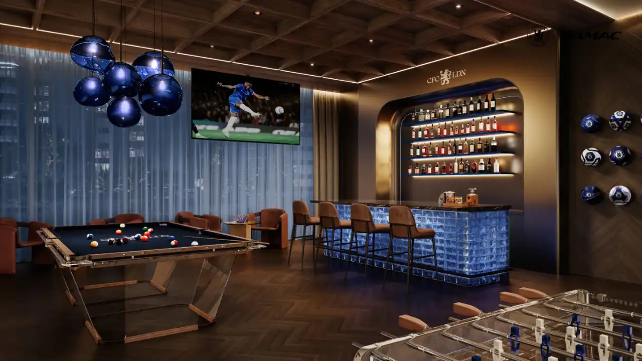 Interior view of the Powerhouse Lounge at DAMAC Chelsea Residences featuring a refined bar, billiards table, foosball area, ambient lighting, and Chelsea themed design elements in Dubai, Presented by Tohid Fetrat