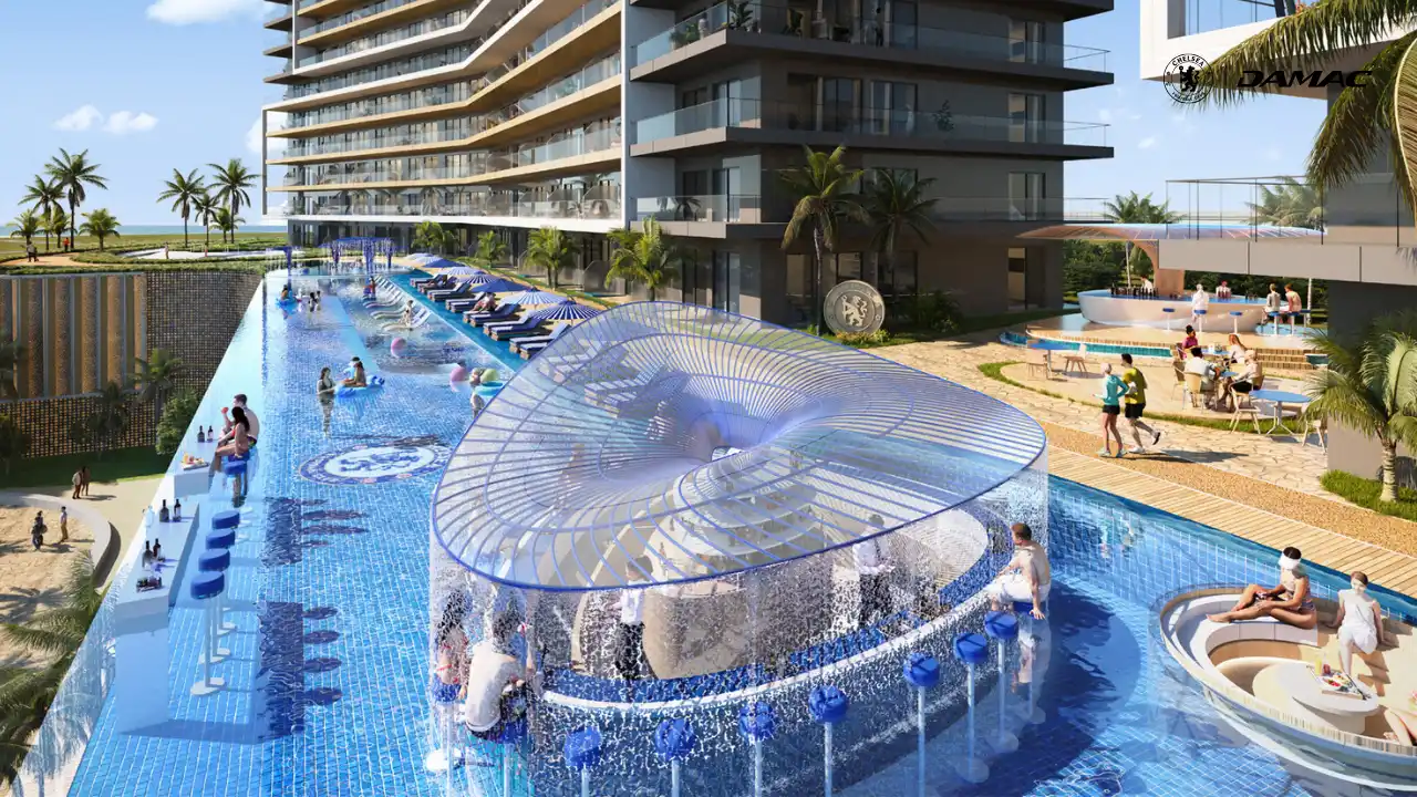 Poolside view of the Sunset Bar at DAMAC Chelsea Residences featuring a circular bar pavilion, flowing water features, blue tiled pools, and a lively waterfront leisure setting in Dubai, Presented by Tohid Fetrat