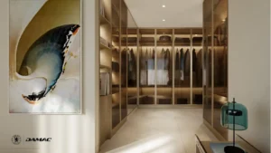 Interior view of the walk-in closet at DAMAC Chelsea Residences featuring custom built wardrobes, glass front cabinetry, warm ambient lighting, and a refined luxury storage space in Dubai, Presented by Tohid Fetrat