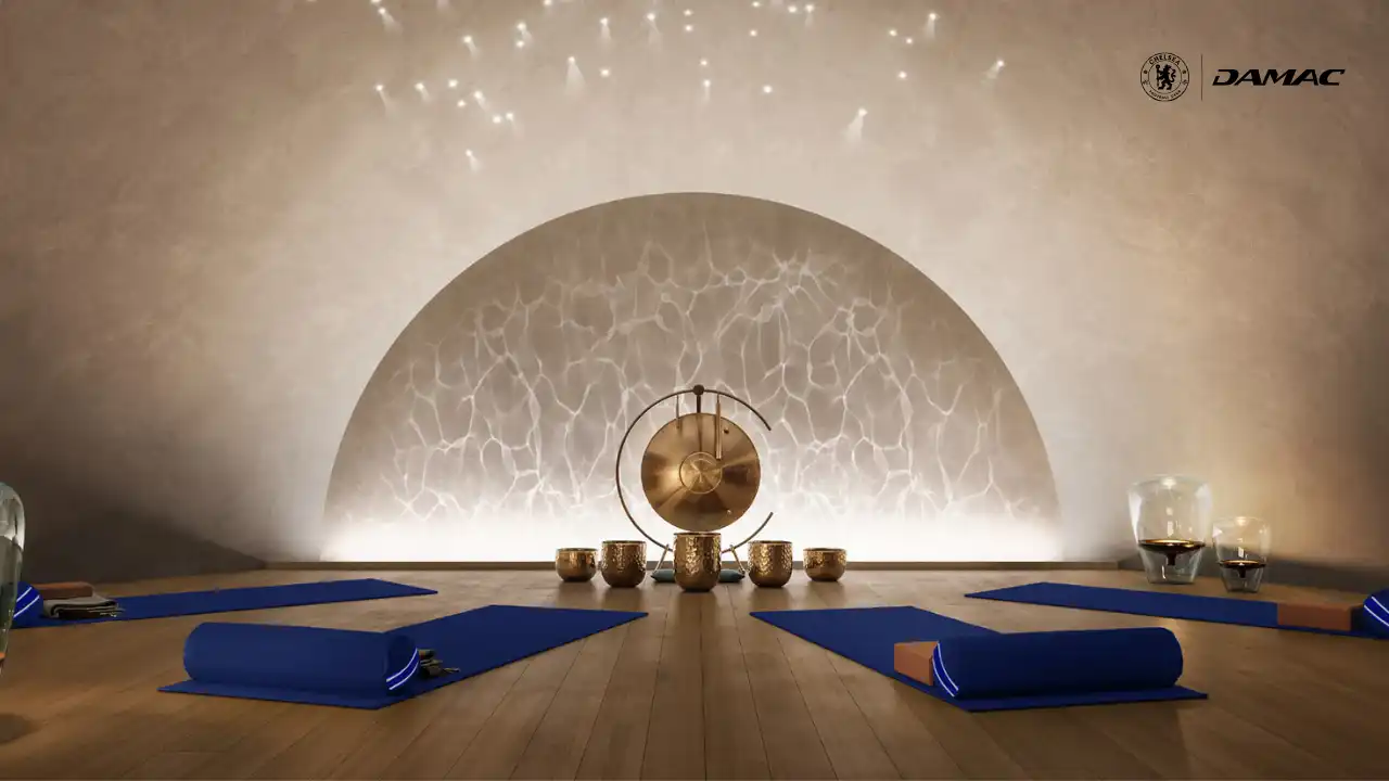 Interior view of the waterfall sound therapy room at DAMAC Chelsea Residences featuring a serene arched backdrop, ambient star like ceiling lighting, yoga mats, and a tranquil wellness setting in Dubai, Presented by Tohid Fetrat
