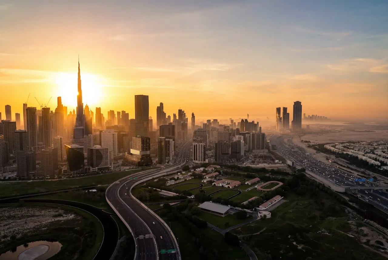 Aerial sunrise view of Haus of Tenet by IRTH in Business Bay, Dubai, with Burj Khalifa and Downtown skyline, major highways, and urban connectivity, presented by Tohid Fetrat
