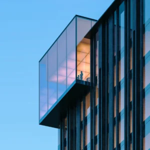 Crown architectural detail of Haus of Tenet by IRTH featuring a glass-enclosed upper level with illuminated interiors, showcasing modern design in Business Bay, Dubai, presented by Tohid Fetrat
