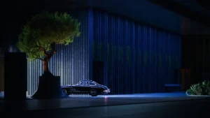 Luxury drop-off entrance at Haus of Tenet in Dubai featuring a classic car, sculptural tree, and dramatic architectural lighting at night, presented by Tohid Fetrat