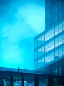 Atmospheric architectural mood image at Haus of Tenet by IRTH showing a contemporary glass façade, layered volumes, and a cinematic blue-toned ambience in Business Bay, Dubai, presented by Tohid Fetrat
