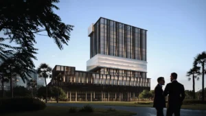 Daytime park view of Haus of Tenet by IRTH in Business Bay, Dubai, featuring a contemporary glass-and-metal architectural composition set within landscaped green areas and palm-lined surroundings, presented by Tohid Fetrat