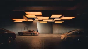 VIP valet visitor parking at Haus of Tenet by IRTH in Business Bay, Dubai, featuring luxury vehicles, sculptural ceiling lighting, and a refined arrival experience designed for executive guests, presented by Tohid Fetrat