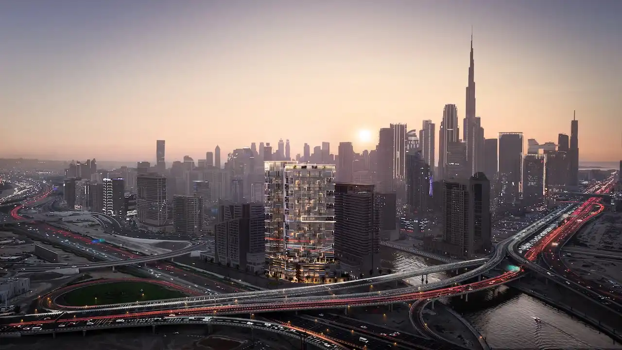 Aerial view of HQ by Rove set within the Dubai cityscape, highlighting a contemporary tower surrounded by major road networks and the Downtown skyline at sunset, Presented by Tohid Fetrat