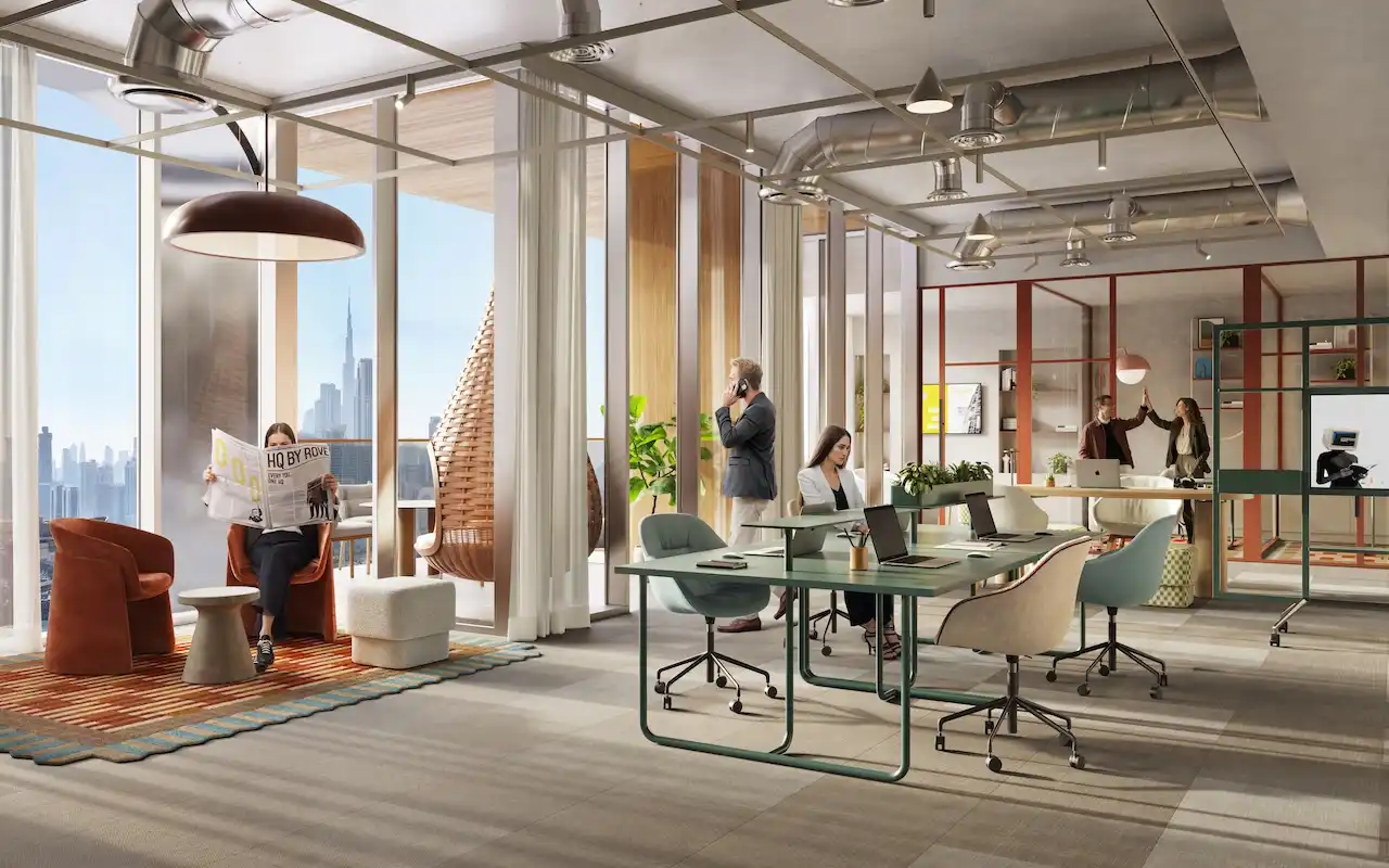 Flexible workspace at HQ by Rove featuring shared workstations, lounge seating, indoor plants, and large windows with Dubai skyline views, Presented by Tohid Fetrat