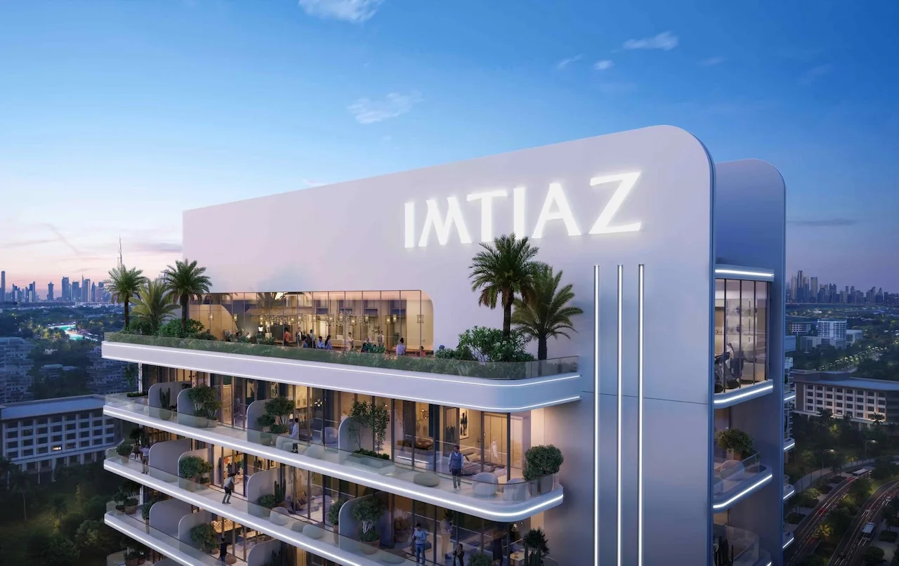 Rooftop exterior view of Le Blanc by Imtiaz featuring illuminated IMTIAZ branding, curved modern architecture, landscaped terraces, and panoramic Dubai skyline views at dusk, Presented by Tohid Fetrat