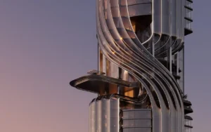 Close-up architectural detail of Lumena Alta showcasing its flowing curved façade and illuminated structural lines at sunset in Dubai. Presented by Tohid Fetrat.