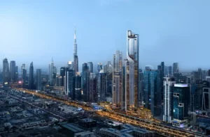 Aerial skyline view of Lumena Alta towers rising along Sheikh Zayed Road with illuminated architectural lines and panoramic views toward Downtown Dubai and Burj Khalifa. Presented by Tohid Fetrat.