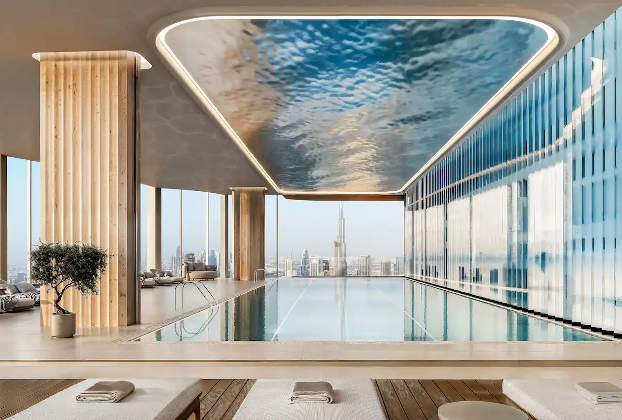 Indoor infinity pool at Lumena Alta with floor to ceiling windows and panoramic views of the Dubai skyline and Burj Khalifa, featuring refined architecture and luxury wellness design. Presented by Tohid Fetrat.