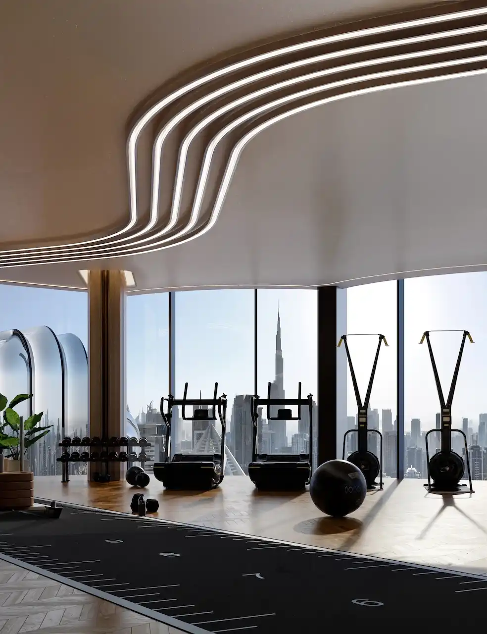 Sky gym at Lumena Alta featuring premium fitness equipment, sculpted ceiling design, floor-to-ceiling windows, and panoramic Burj Khalifa views in Dubai. Presented by Tohid Fetrat.