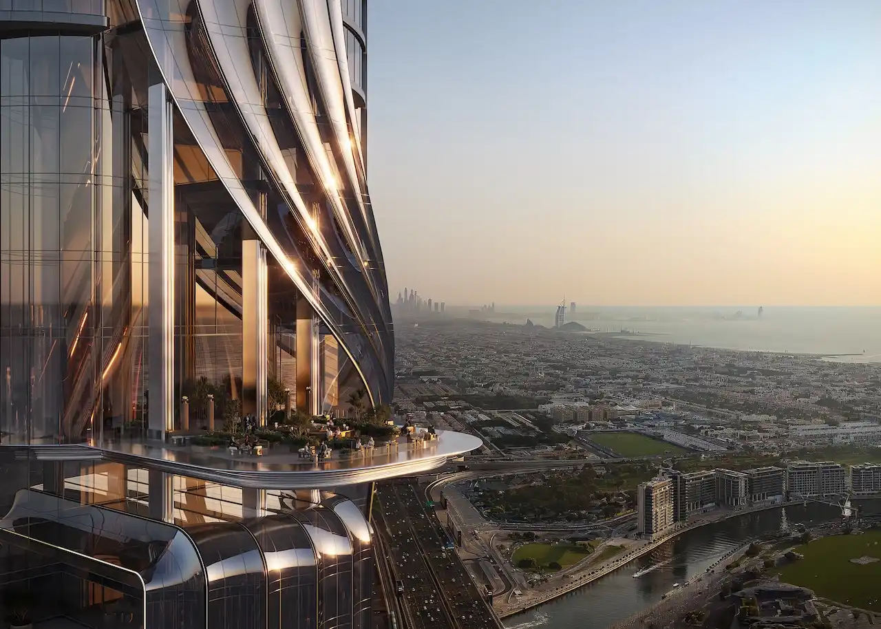 Elevated sky terrace at Lumena Alta featuring a sculptural glass façade and expansive sunset views across Dubai’s cityscape and coastline. Presented by Tohid Fetrat.