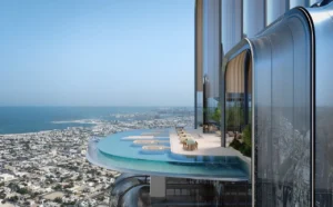 Lumena Alta elevated sky terrace and cantilevered infinity pool overlooking Dubai’s urban landscape and coastline during daytime. Presented by Tohid Fetrat.