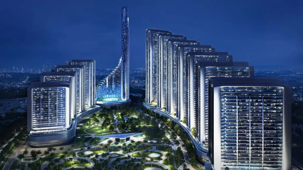 Night aerial view of Mercedes Benz Places-Binghatti City featuring illuminated residential towers arranged in a stepped formation, landscaped central podium gardens, and a glowing vertical landmark within the Dubai skyline. Presented by Tohid Fetrat.