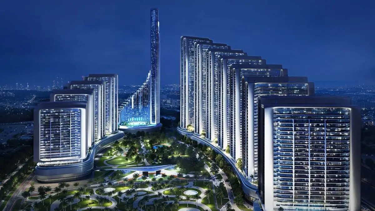 Night aerial view of Mercedes Benz Places-Binghatti City featuring illuminated residential towers arranged in a stepped formation, landscaped central podium gardens, and a glowing vertical landmark within the Dubai skyline. Presented by Tohid Fetrat.