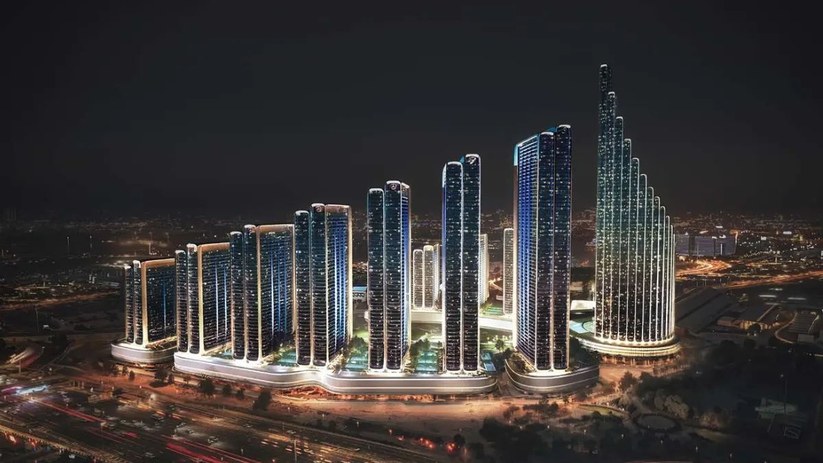 Night exterior view of Mercedes Benz Places-Binghatti City featuring illuminated stepped residential towers, vertical lighting accents, a continuous podium base, and surrounding Dubai urban roads. Presented by Tohid Fetrat.