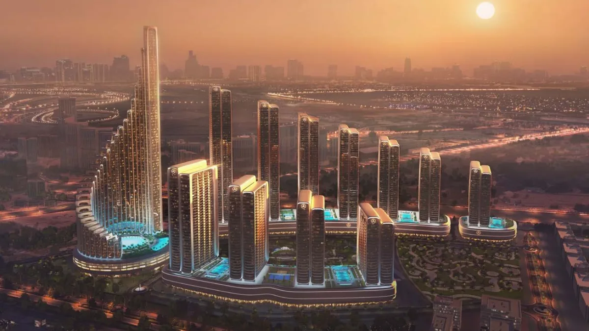 Sunset aerial view of Mercedes Benz Places-Binghatti City showing stepped high rise towers, illuminated podium levels, landscaped courtyards, and the surrounding Dubai city skyline at golden hour. Presented by Tohid Fetrat.