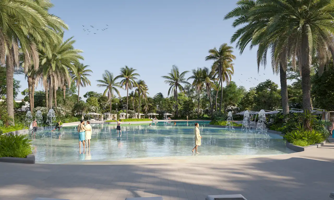 Lagoon-style swimming pool at Daintree Park in Sobha Elwood, featuring palm-lined landscaping, shallow water zones, and resort-inspired outdoor leisure spaces within a master-planned residential community in Dubai, Presented by Tohid Fetrat