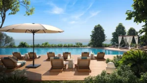 Pool deck at Soulever featuring a seafront infinity pool, sun loungers, shaded cabanas, and landscaped greenery overlooking the Gulf in Dubai. Presented by Tohid Fetrat.