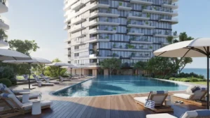 Poolside area at Soulever residences featuring a landscaped wooden deck, sun loungers, and a serene swimming pool with Gulf views in Dubai. Presented by Tohid Fetrat.