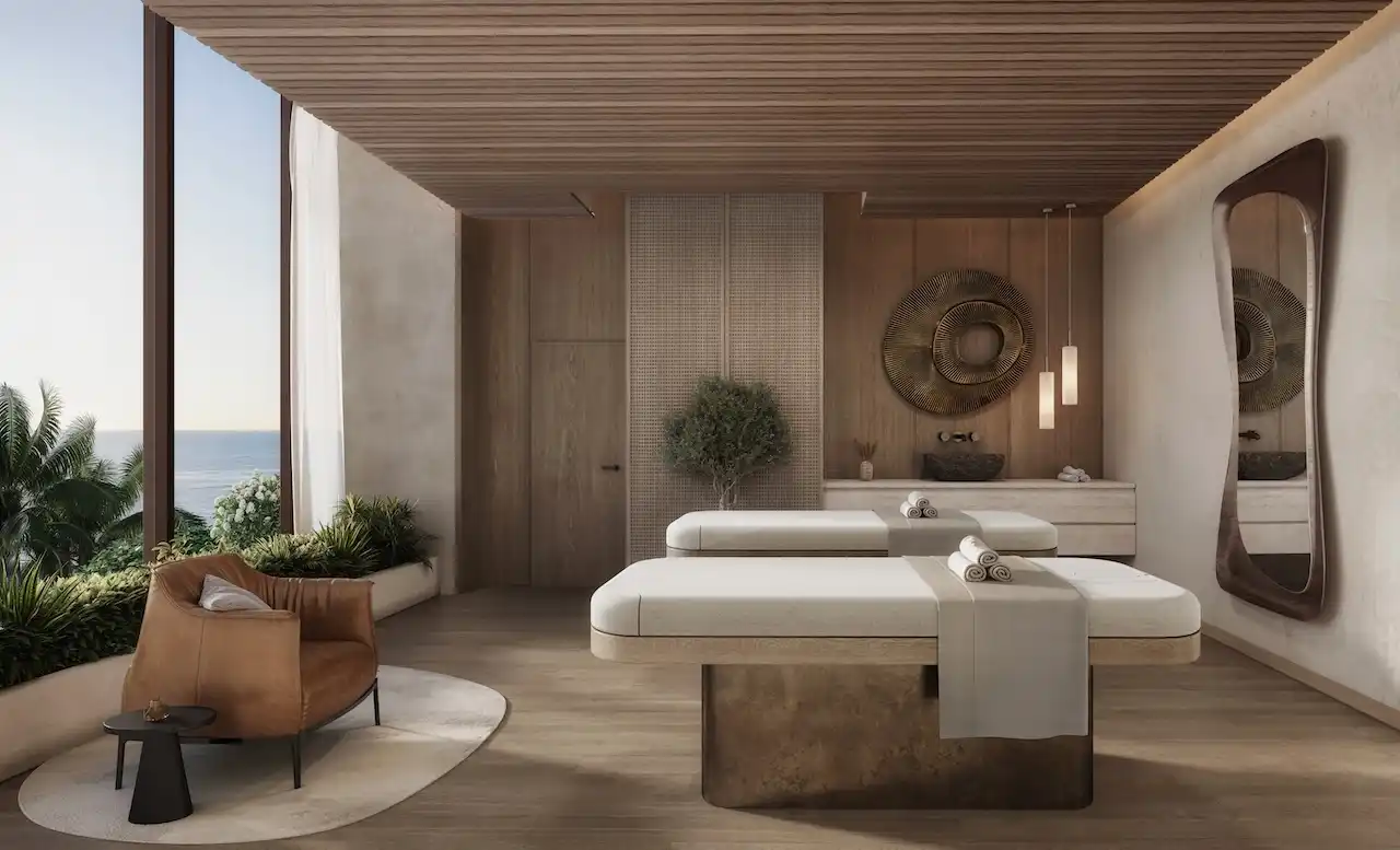 Luxury spa treatment room at Soulever featuring dual massage beds, natural wood finishes, soft lighting, and a serene Gulf view within a high-end residential development in Dubai. Presented by Tohid Fetrat.