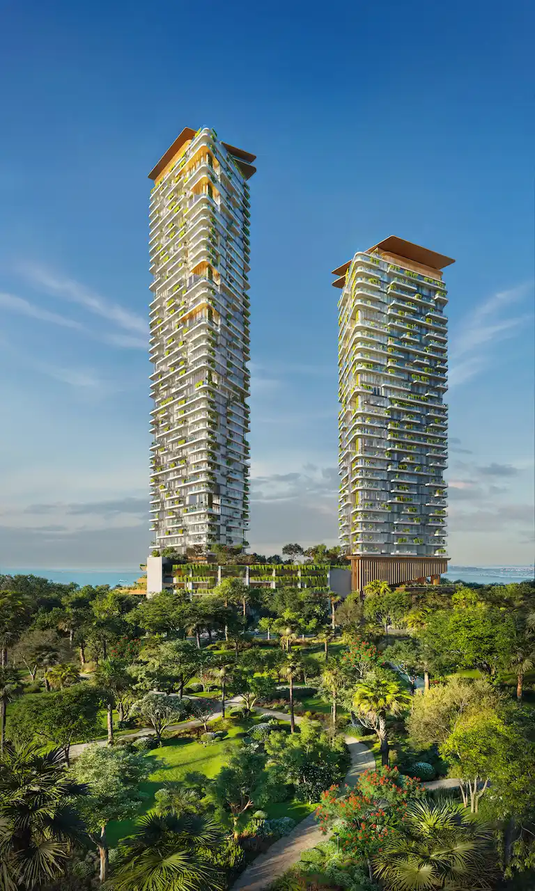 Daytime forest view of Soulever twin residential towers rising above lush landscaped gardens, featuring layered balconies, integrated greenery, and panoramic Gulf views in Dubai. Presented by Tohid Fetrat.