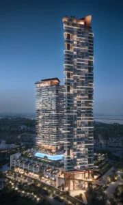 Night view of Soulever twin residential towers illuminated against the skyline, rising above landscaped podium gardens and luxury amenities with Gulf views in Dubai. Presented by Tohid Fetrat.