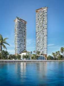 Daytime water view of Soulever twin residential towers rising above the Gulf, featuring elegant stepped balconies, vertical greenery, and a waterfront setting in Dubai. Presented by Tohid Fetrat.