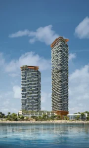 Daytime waterfront view of Soulever twin residential towers overlooking the Gulf, featuring stepped balconies, vertical greenery, and contemporary architecture in Dubai. Presented by Tohid Fetrat.