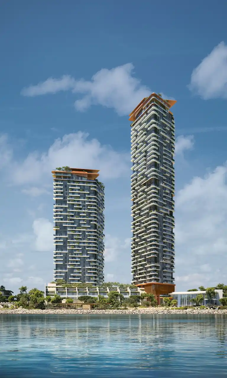 Daytime waterfront view of Soulever twin residential towers overlooking the Gulf, featuring stepped balconies, vertical greenery, and contemporary architecture in Dubai. Presented by Tohid Fetrat.