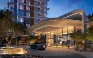 Evening view of the illuminated entrance canopy and drop-off area with sculpted architecture and glass façade at The Edit at d3 in Dubai Design District, Presented by Tohid Fetrat