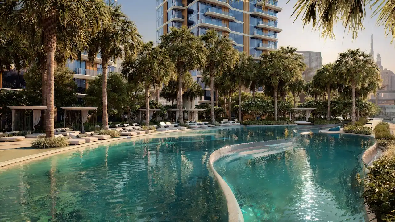 Lagoon-style swimming pool with palm trees, cabanas, and luxury residential towers at The Edit at d3 in Dubai Design District, Presented by Tohid Fetrat