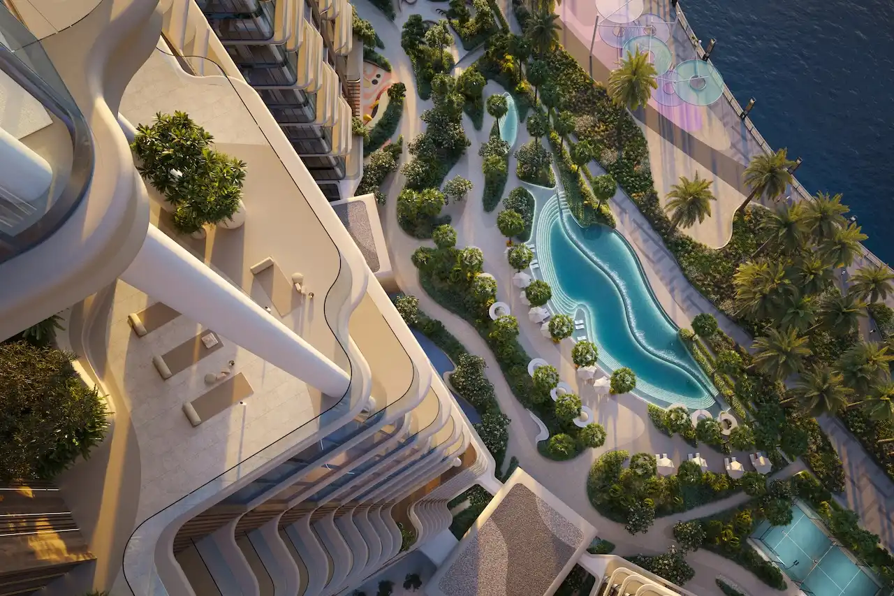 Aerial view of The Edit at d3 landscaped podium with curving swimming pool and waterfront promenade in Dubai Design District, Presented by Tohid Fetrat