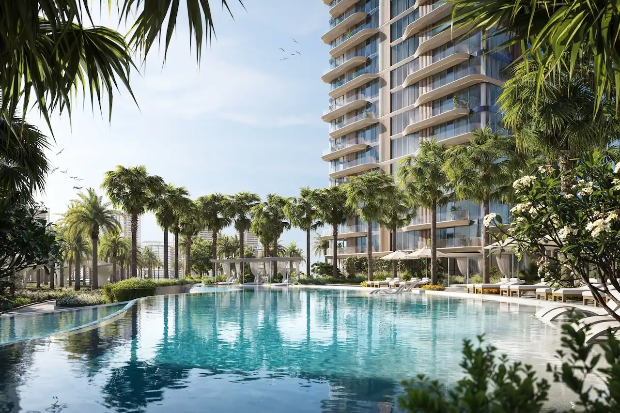 Palm-lined lagoon-style swimming pool at The Edit at d3 with sun loungers, cabanas, and contemporary residential towers in Dubai Design District, Presented by Tohid Fetrat