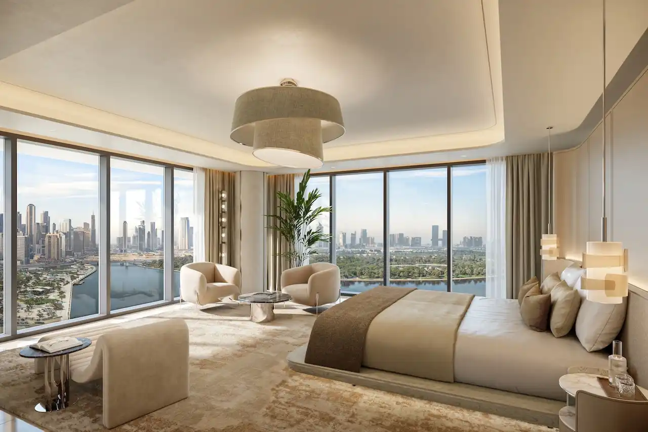 Luxury penthouse master bedroom interior at The Edit at d3 featuring floor-to-ceiling windows, panoramic Dubai skyline and waterfront views, refined neutral tones, and elegant contemporary design, Presented by Tohid Fetrat