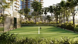 Outdoor padel tennis court at The Edit at d3 surrounded by lush landscaping, palm trees, and modern residential towers in Dubai Design District, Presented by Tohid Fetrat