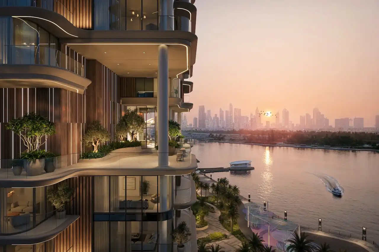 Sunset view from a waterfront balcony at The Edit at d3 overlooking Dubai Canal and the city skyline, featuring curved terraces and contemporary architecture, Presented by Tohid Fetrat
