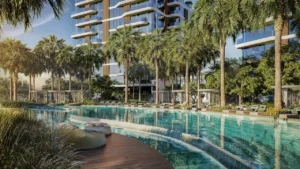 Waterfront swimming pool surrounded by palm trees and luxury residential towers at The Edit at d3 in Dubai Design District, Presented by Tohid Fetrat