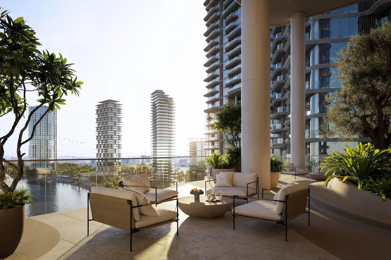Waterfront terrace seating at The Edit at d3 overlooking Dubai Canal and contemporary towers, featuring shaded columns, landscaped planters, and elegant outdoor furniture, Presented by Tohid Fetrat